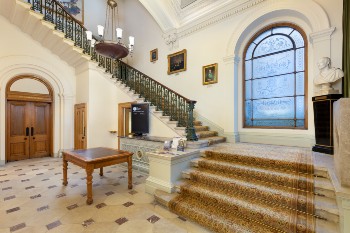 sweeping staircase with huge arched window